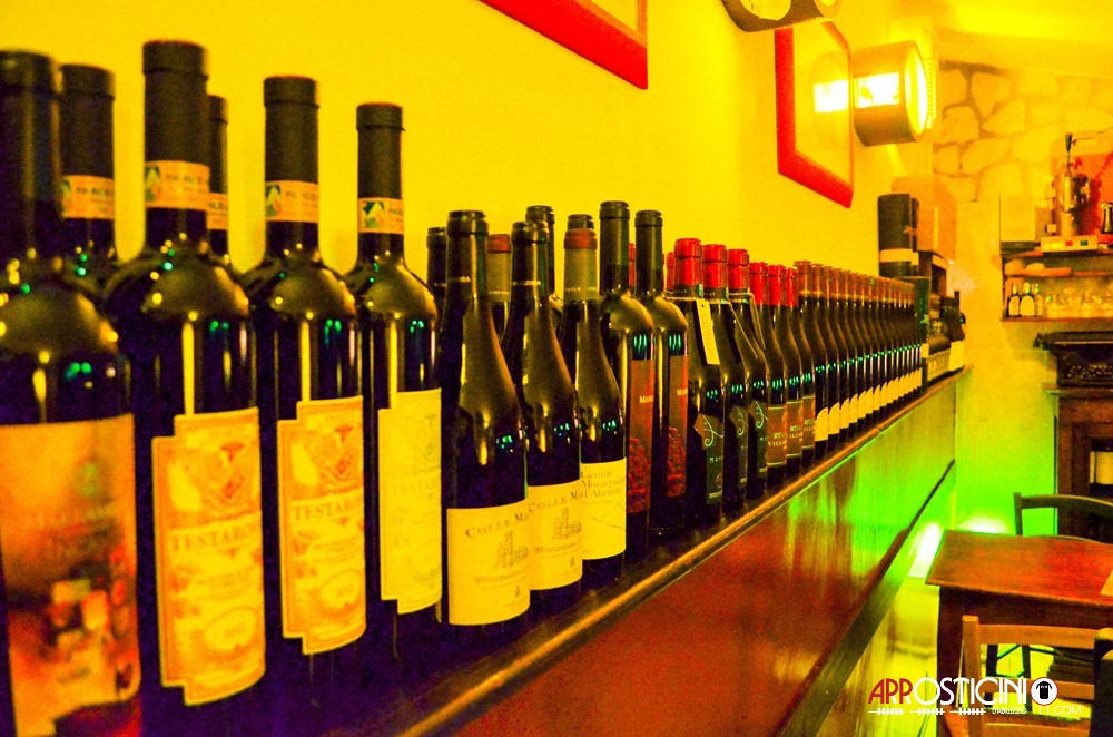 bottiglie di Montepulciano sul bancone nell'Unico Posto ristorante di arrosticini classici e  fegato l'Aquila Abruzzo